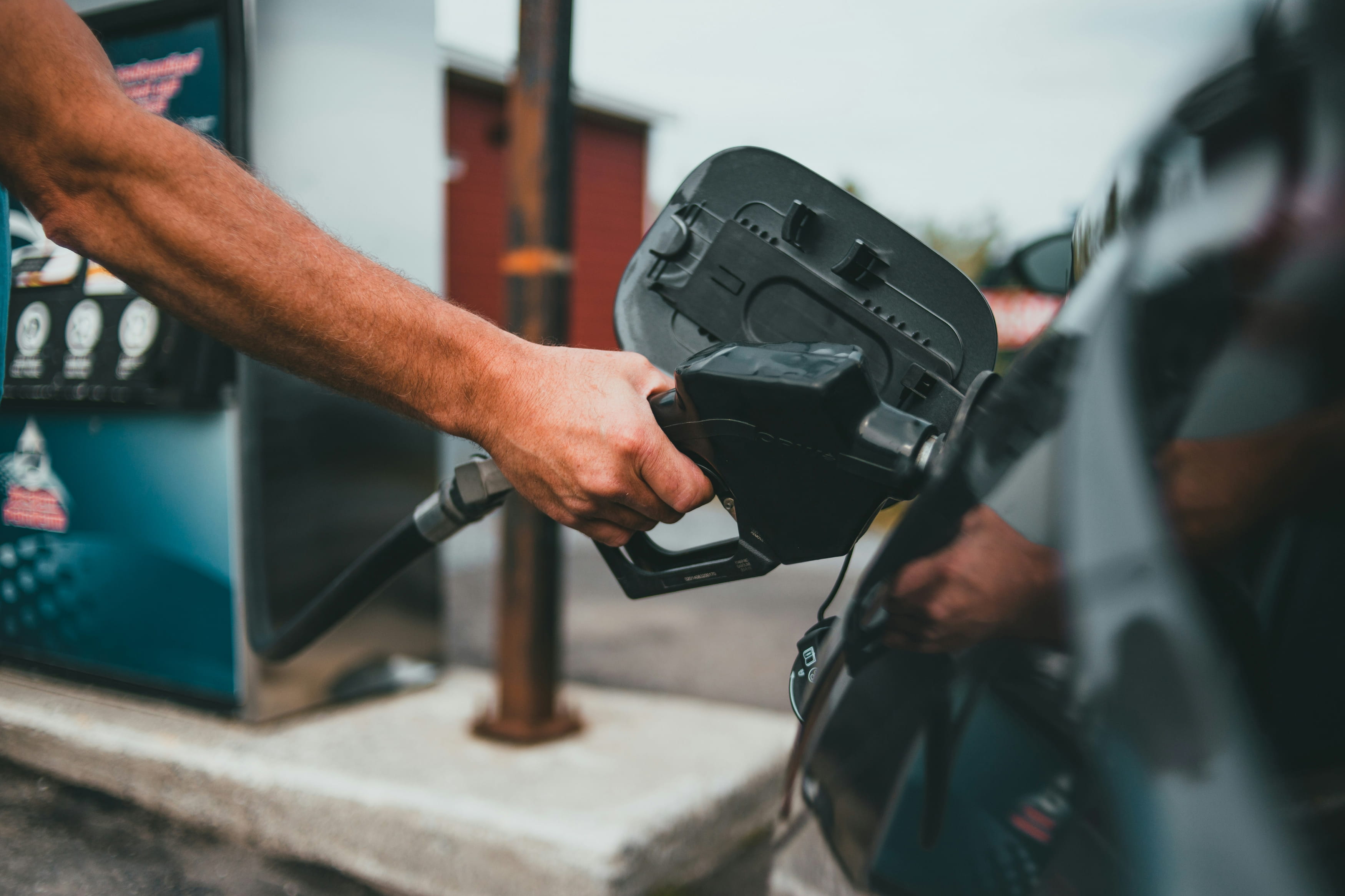 A person pumping gasoline at a gas station