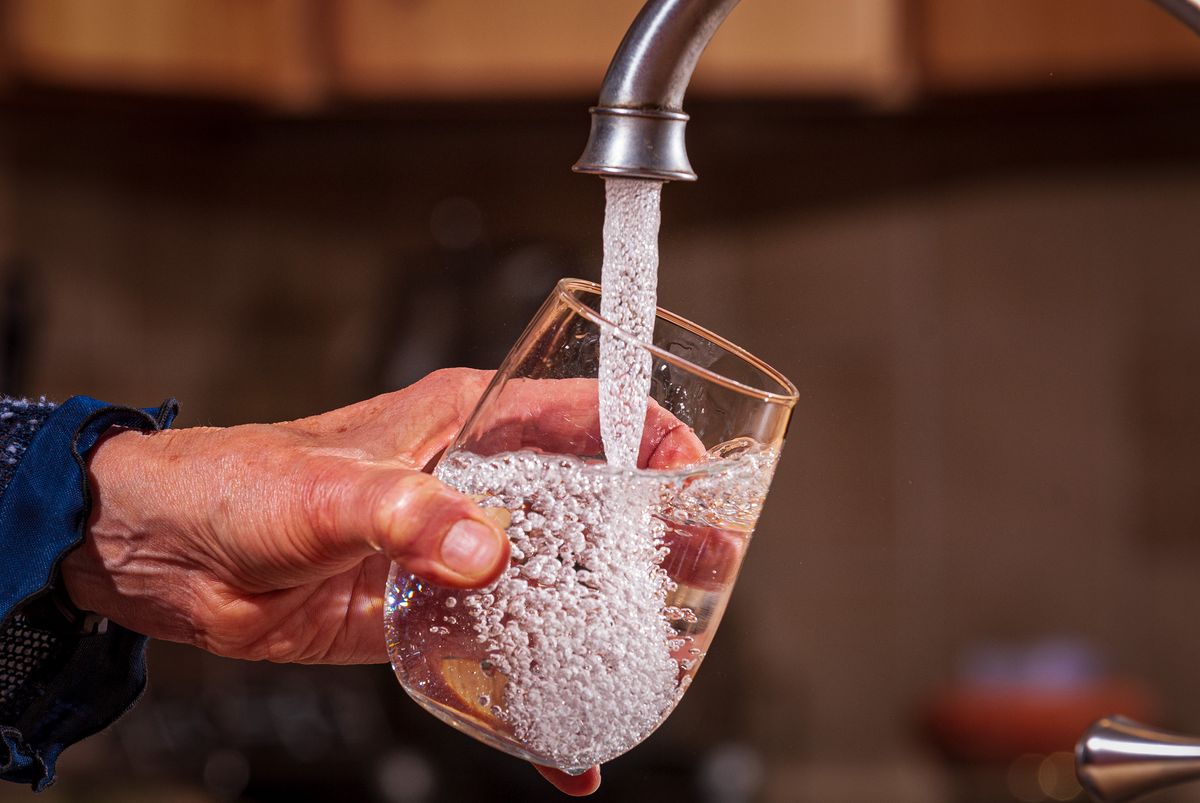 A glass of water being filled from a tap