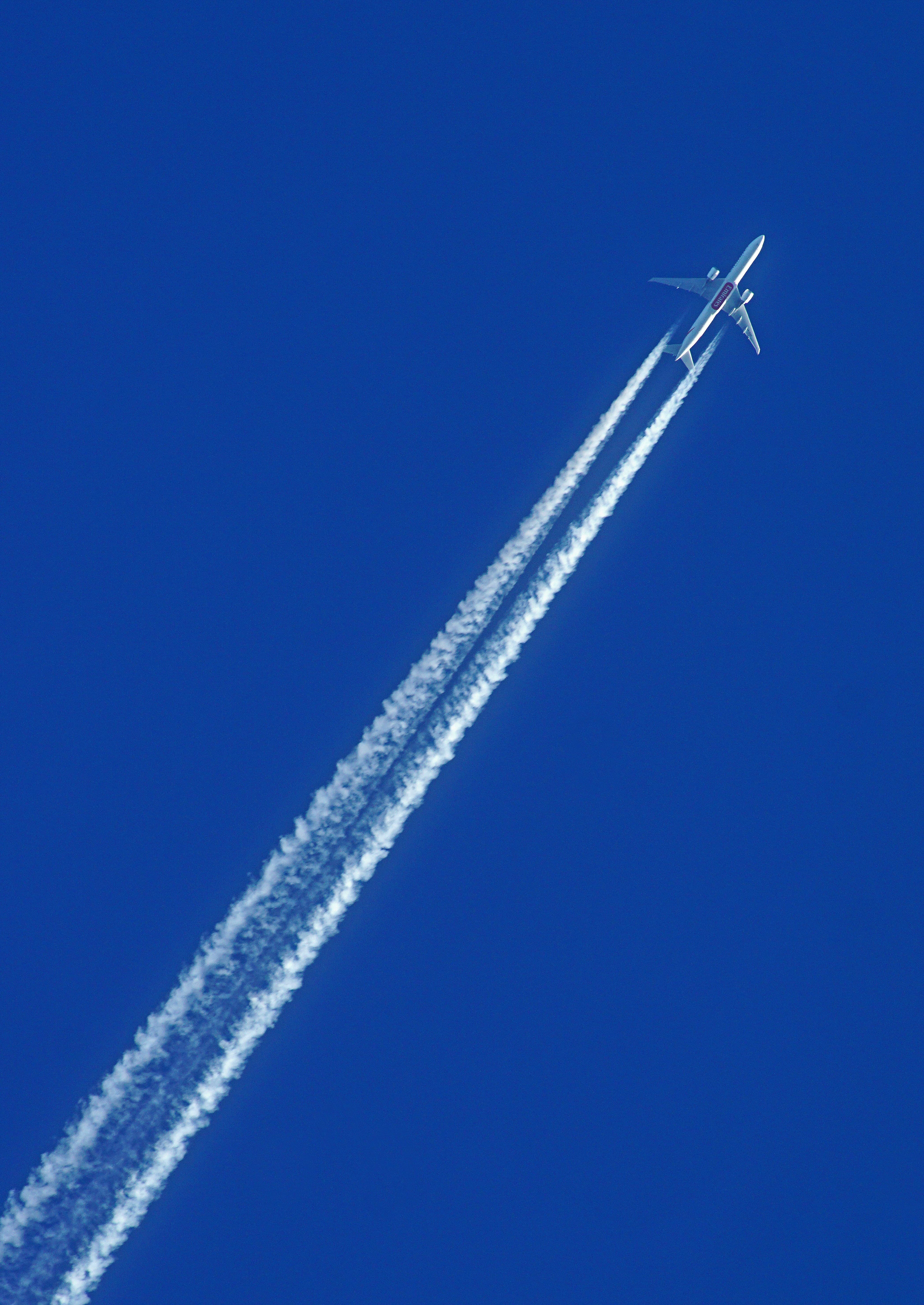 Airplane leaving a contrail across a blue sky
